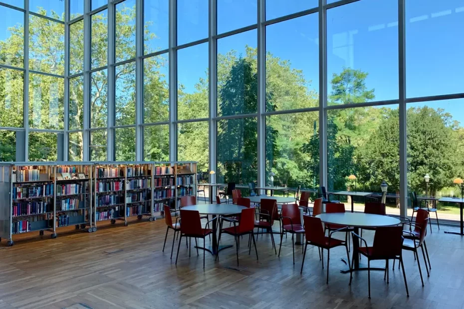 library shelves, chairs and tables in glass walled room