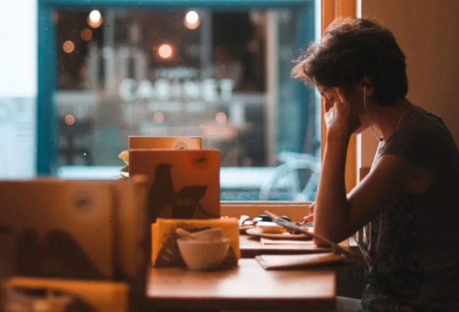 image of woman in cafe looking at tablet screen